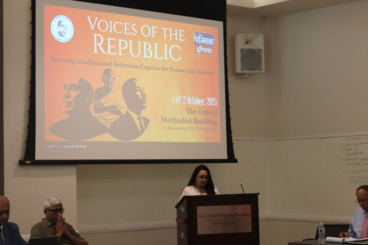 Speaker at the podium — full view with backdrop