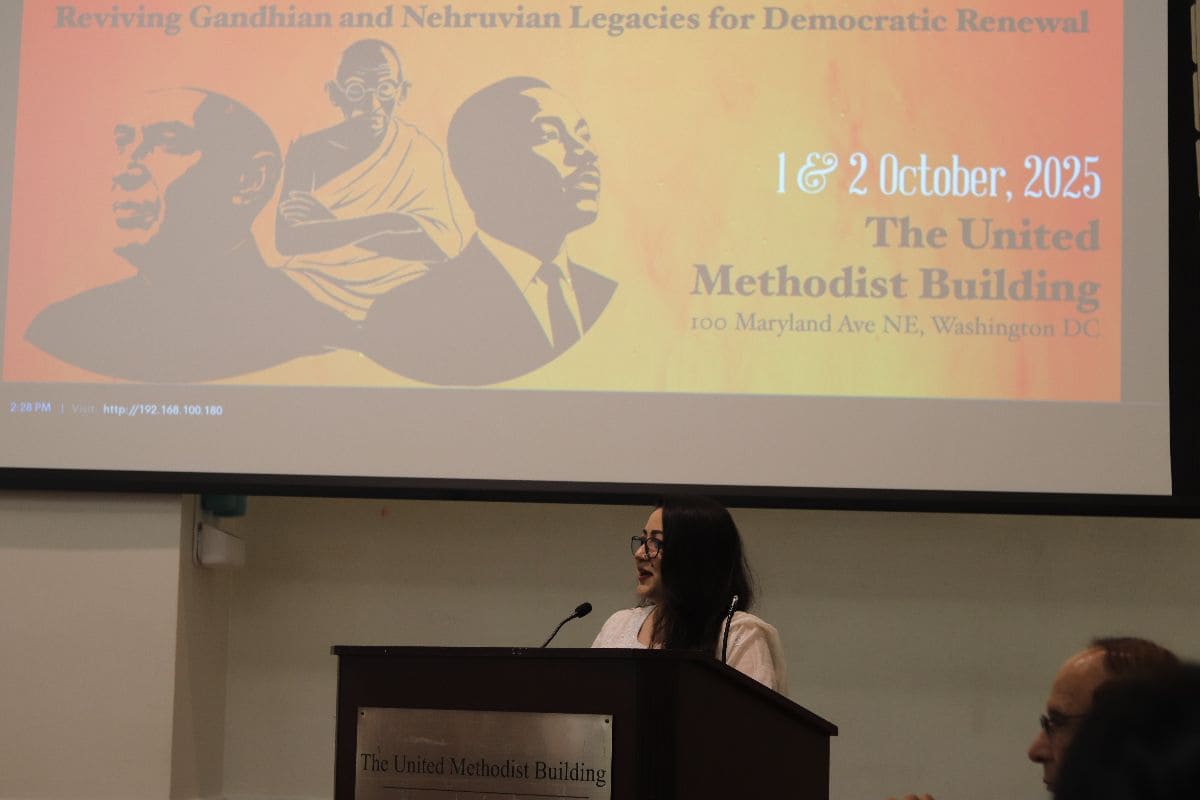 Speaker at podium — close-up with event banner